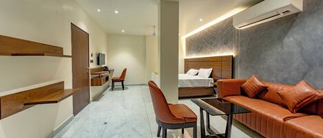 Una habitación de hotel moderna con una cama, un sofá, un escritorio y una silla.