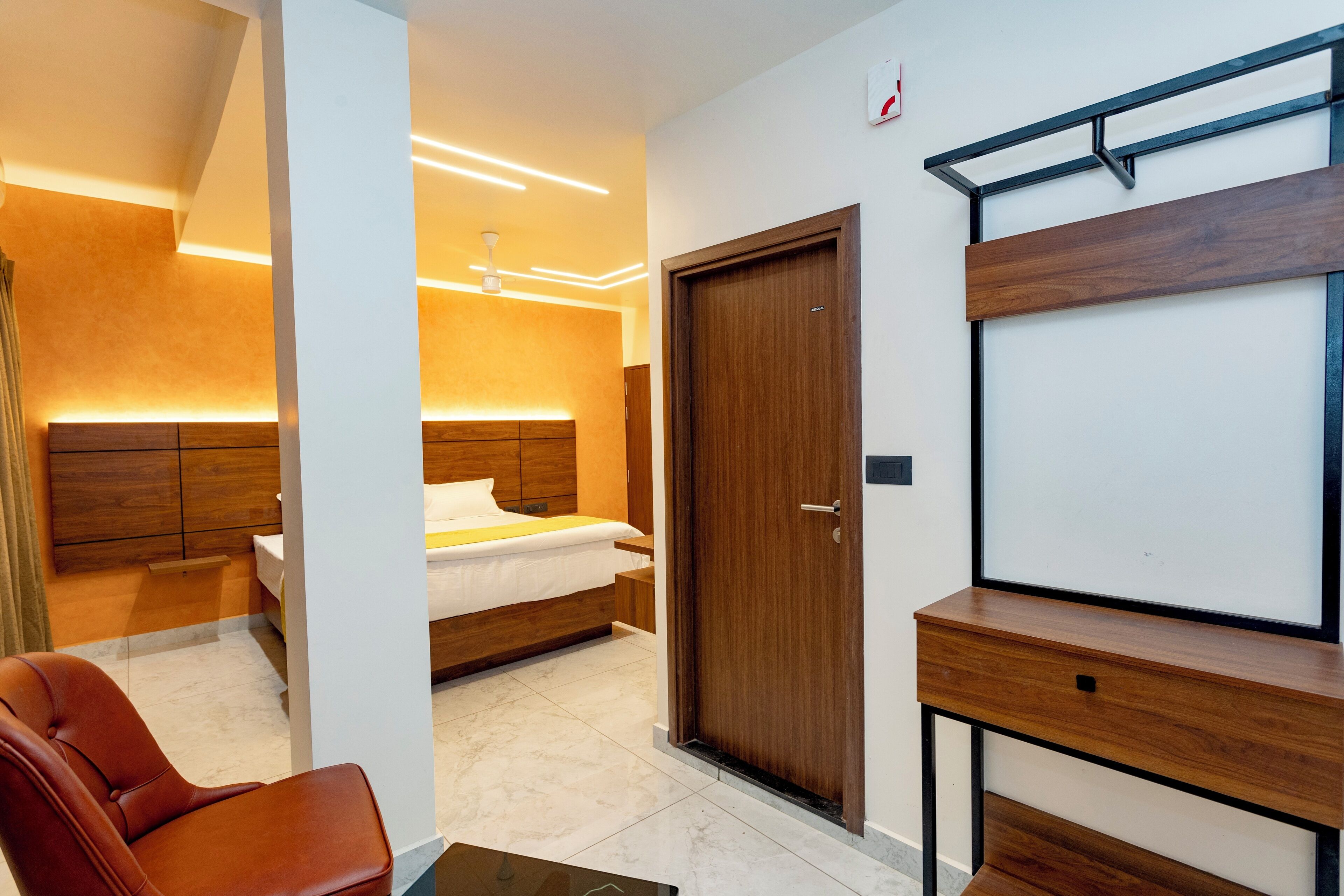 A modern hotel room with a wooden bed, a desk, and a chair.