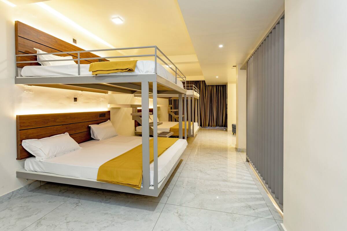 A bunk bed room with a wooden headboard, a yellow blanket, and a marble floor.