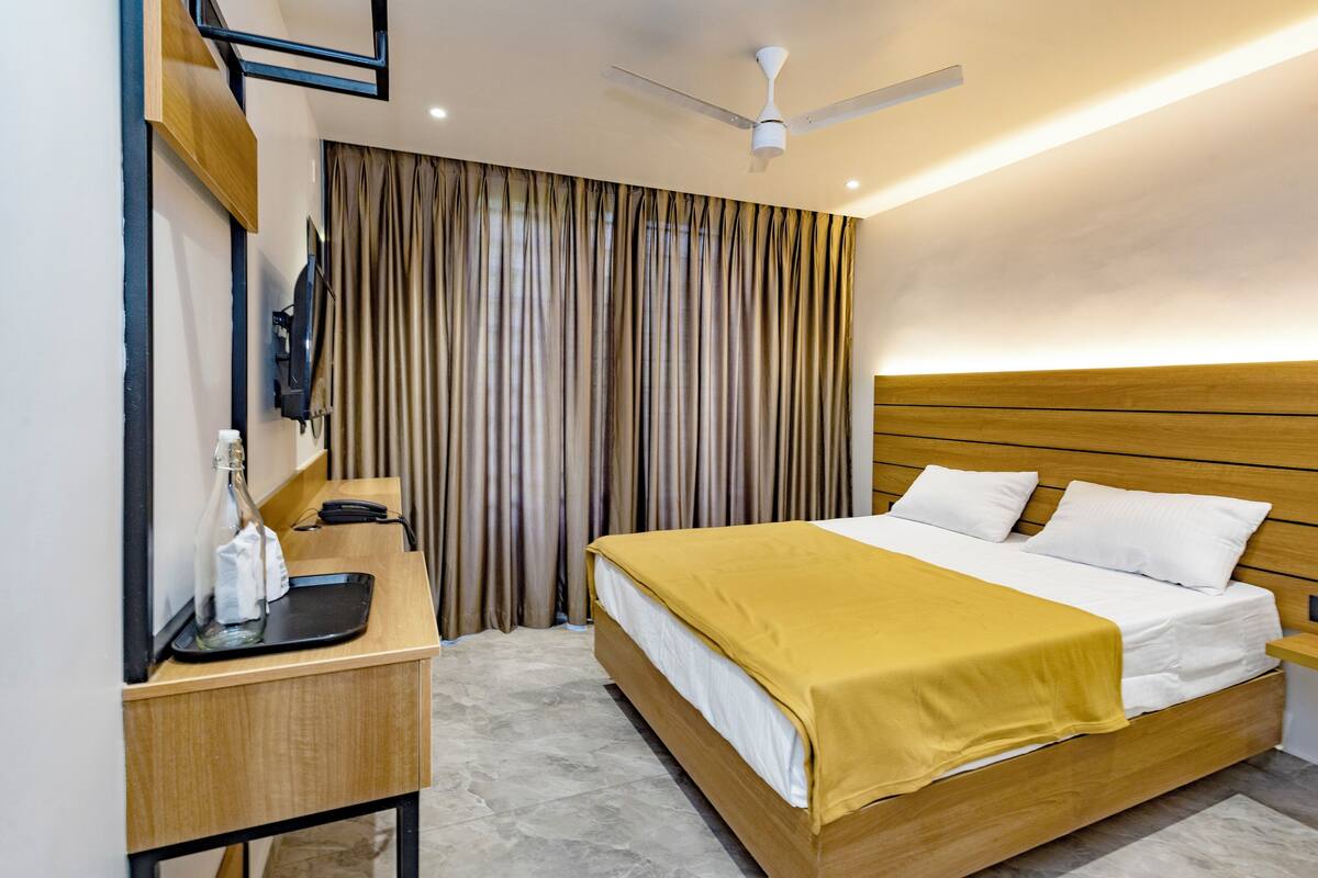 A hotel room with a bed, bedside table, and a ceiling fan.