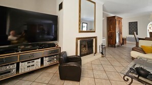 Un salon doté d’un grand téléviseur à écran plat, d’une cheminée, d’un meuble en bois et d’un canapé.