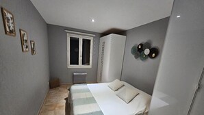 Une chambre à coucher avec un lit, une armoire et une fenêtre.