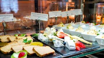 A buffet with various food items including sandwiches, cheese, and fruits.