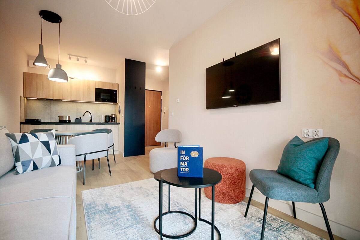 A modern living room with a sofa, a coffee table, and a TV mounted on the wall.