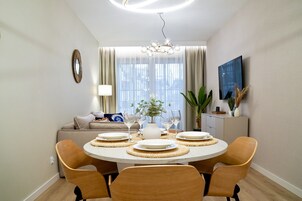 Ein Essbereich mit einem runden Tisch, Stühlen und einer Chandelüster.