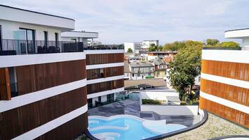 Un edifici modern amb una piscina al terrat i vistes al barri circumdant.