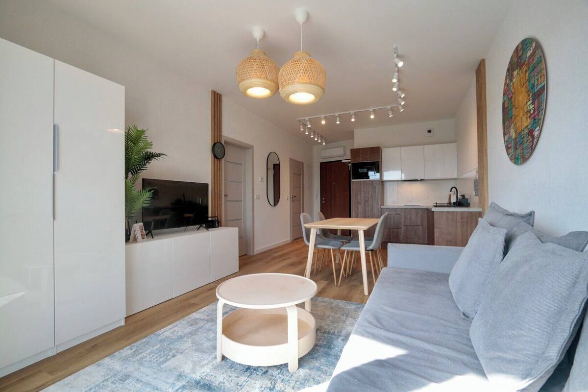 A modern apartment with a living room, dining area, and kitchen.