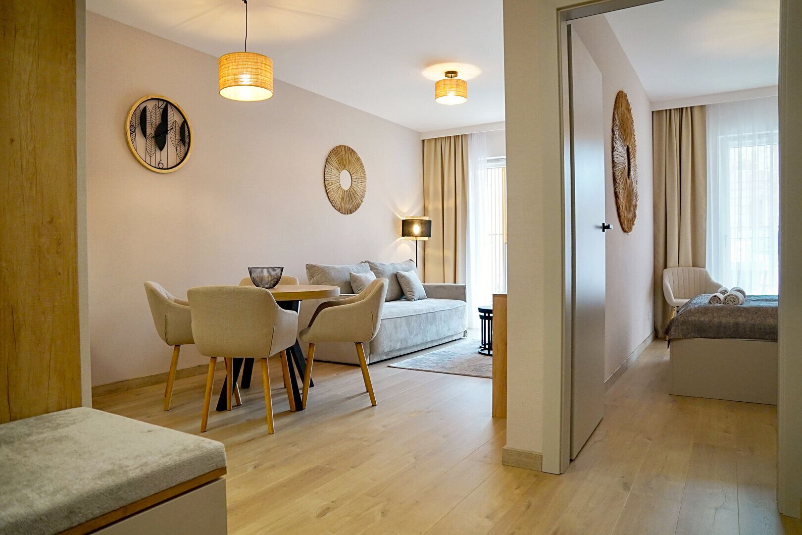 A modern living room with a dining area, a sofa, and a bed.
