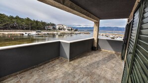 A balcony with a view of a calm body of water, boats, and distant mountains. - Villa Sana, on the beach with swimming pool (Vir)