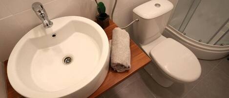 A bathroom with a white sink, toilet, and shower.
