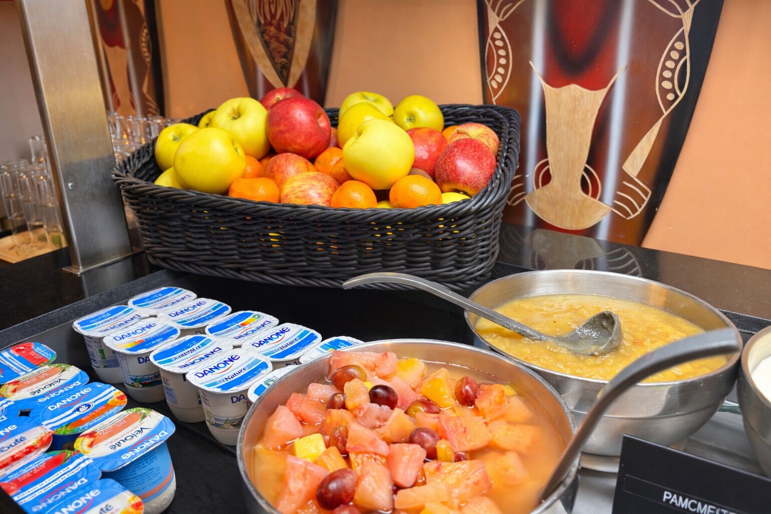 A buffet with fruits, yogurt, and soup.