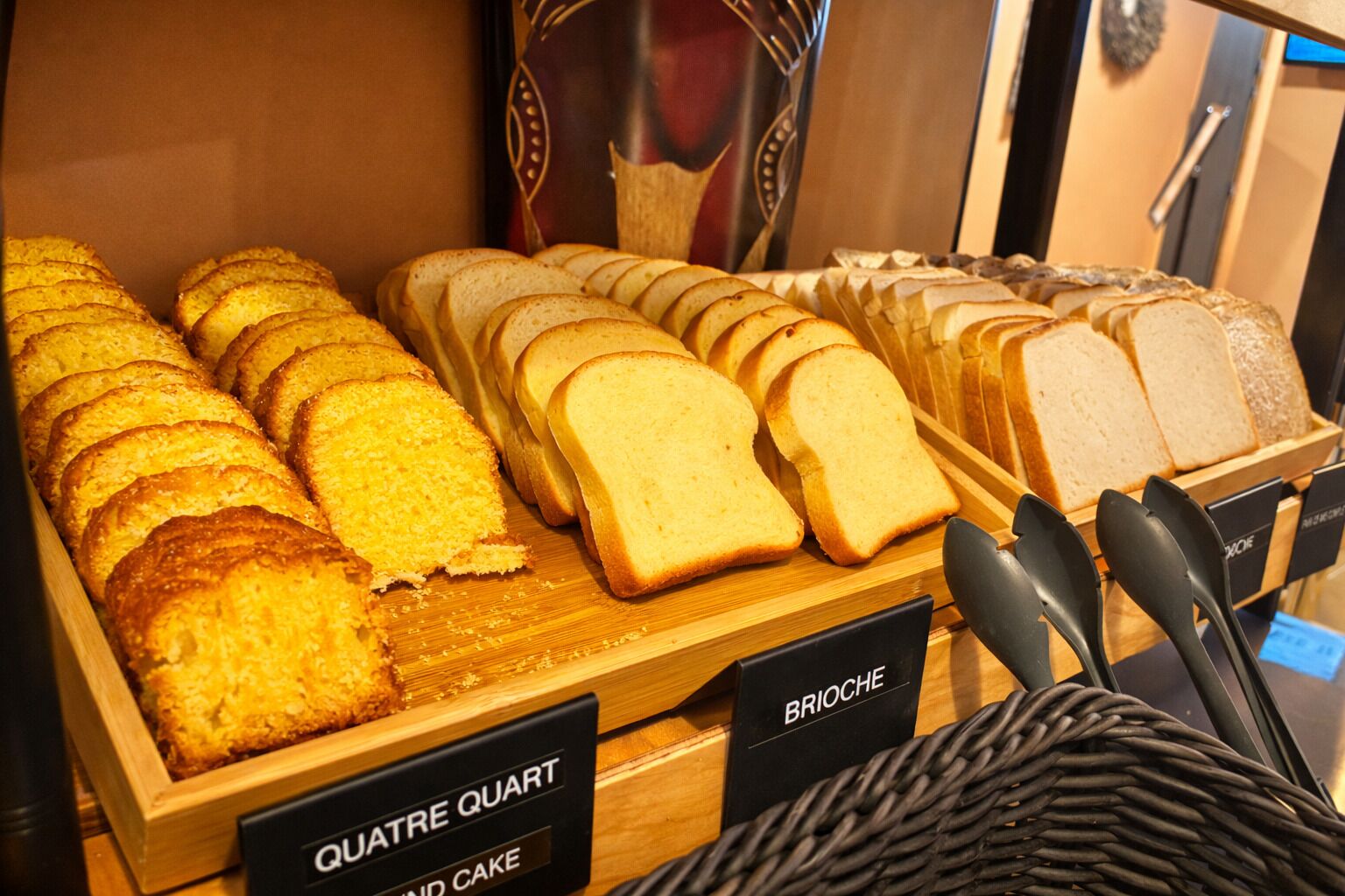 A bakery display with various types of bread and pastries.