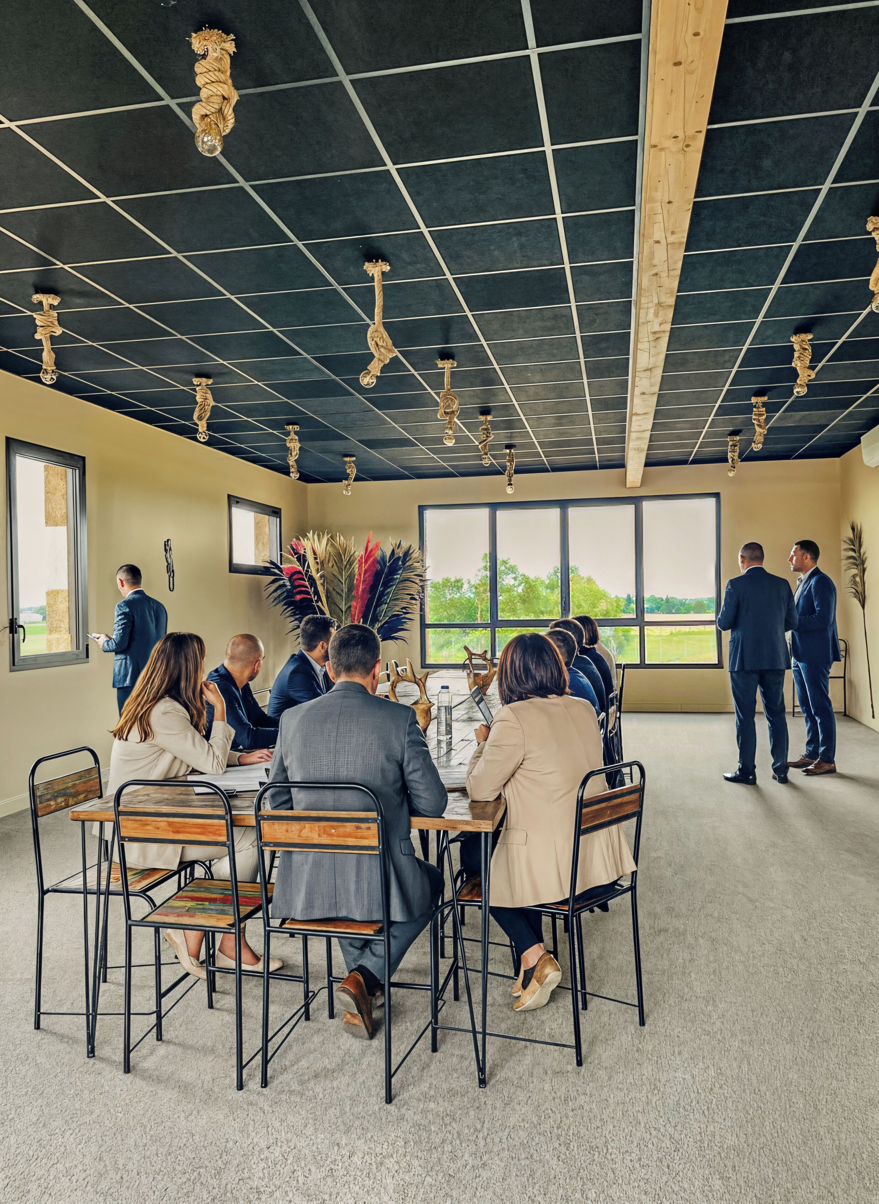 Un salón de conferencias con techo alto, vigas de madera y un ventanal con vistas al exterior.