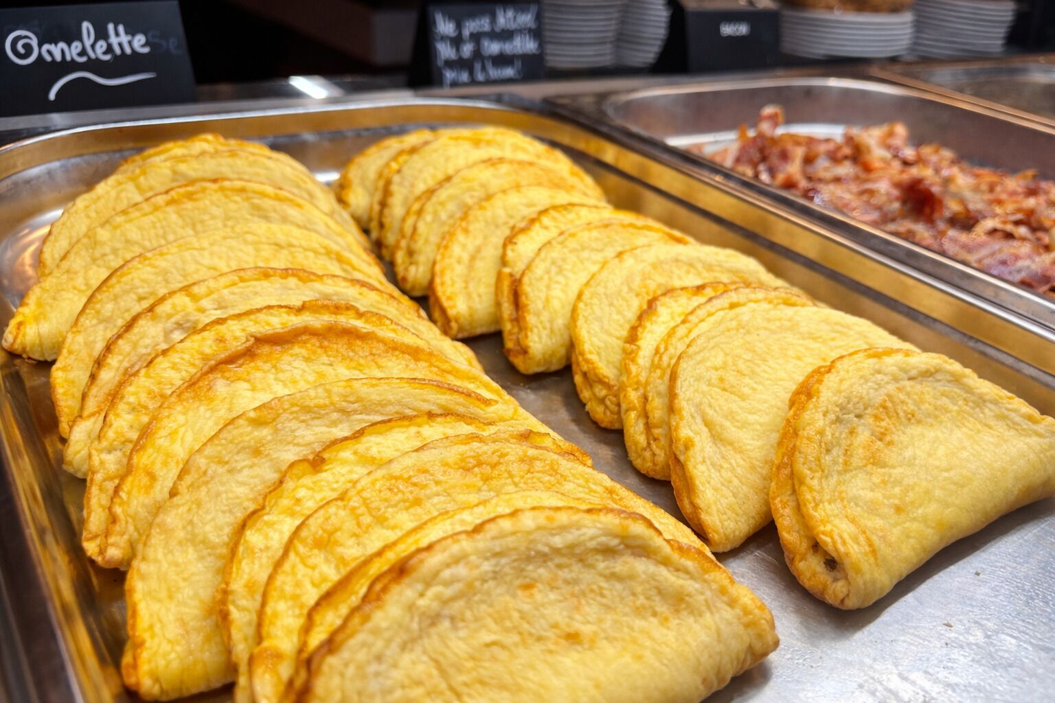 Un bufé con una variedad de alimentos, incluyendo una bandeja de pasteles dorados.