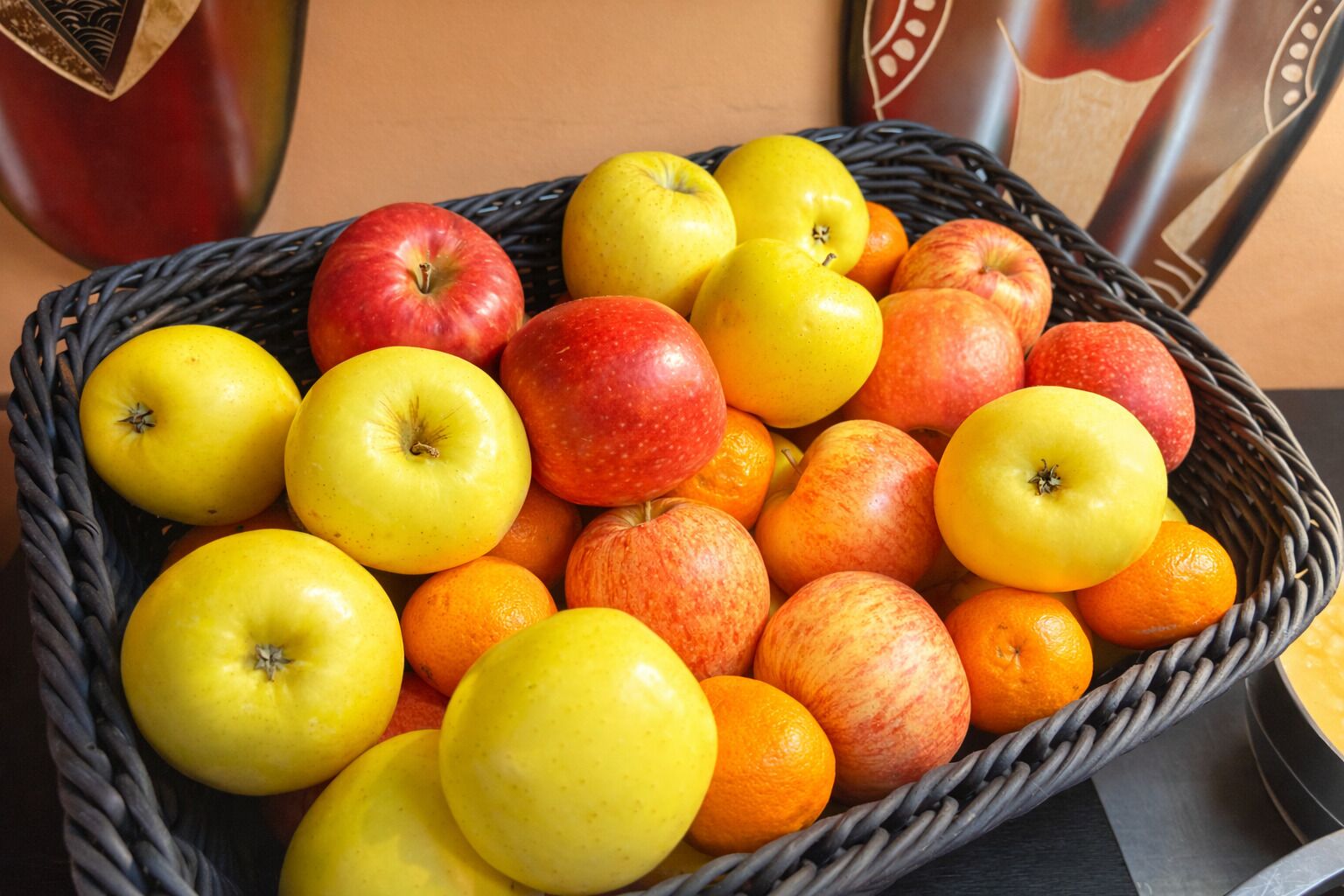 Una cesta llena de manzanas y naranjas.