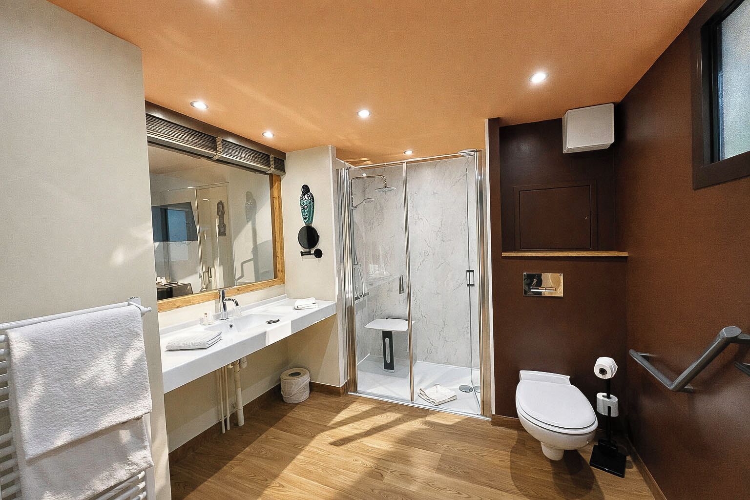 A modern bathroom with a shower, toilet, and sink.