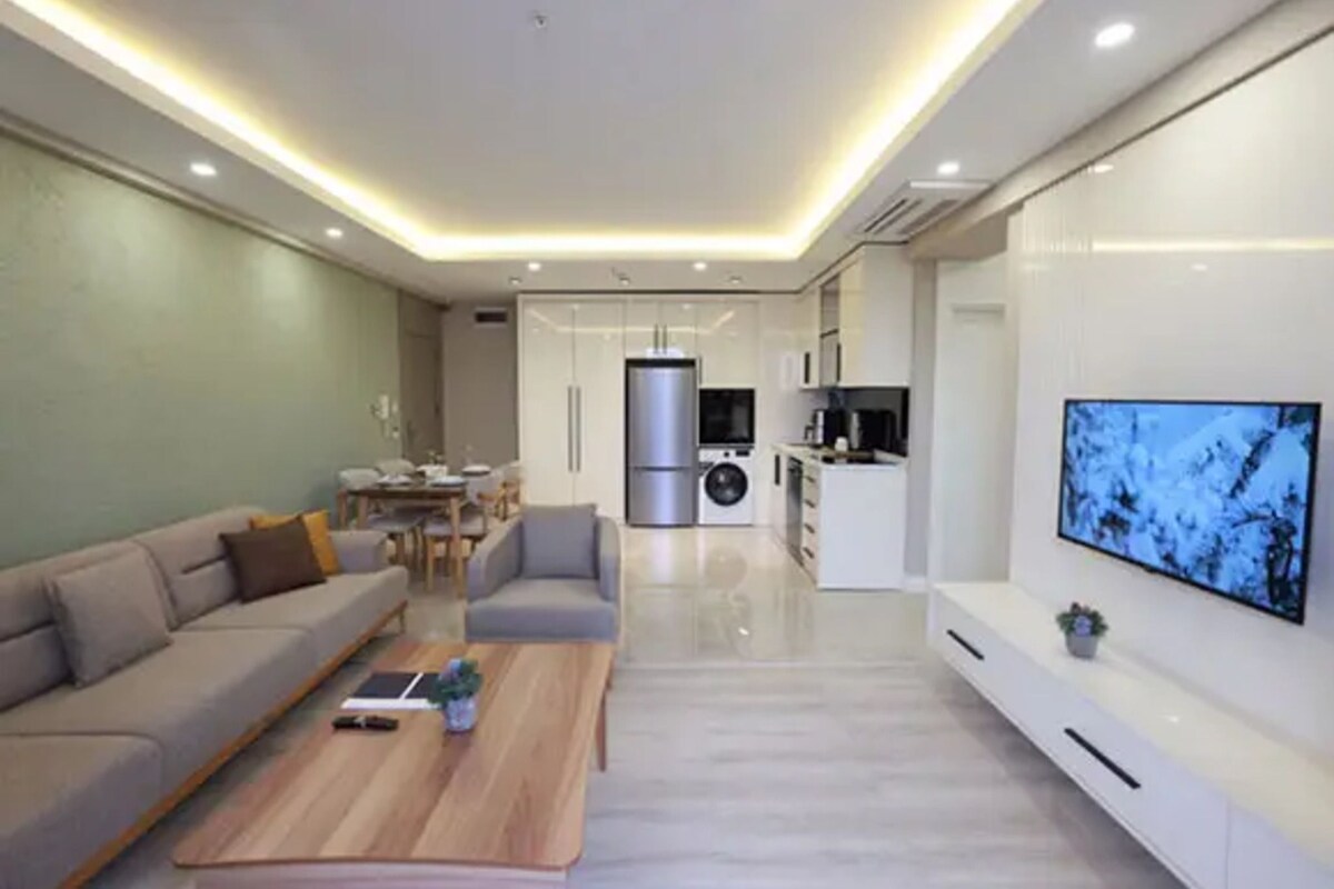 A modern living room with a sofa, coffee table, and TV.