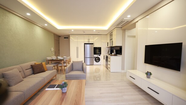 A modern living room with a sofa, coffee table, and TV.