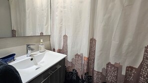 Ein Badezimmer mit einem weißen Waschbecken, einem Spiegel und einer Seife.