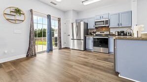 Une cuisine moderne avec des meubles de couleur bleu clair, des appareils en acier inoxydable et un grand îlot central.