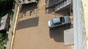 An aerial view of a parking lot with two cars parked. - Clinton Hotel (Kikuyu)