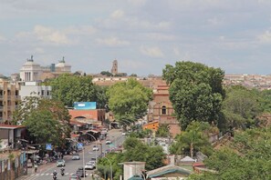 A cityscape with a prominent historical building with domes and a tower, surrounded by greenery and modern buildings. - Rifugio incantato sul fiume Tevere (Rome)