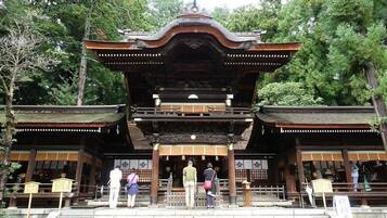A traditional Japanese gate with intricate woodwork and a central pillar.