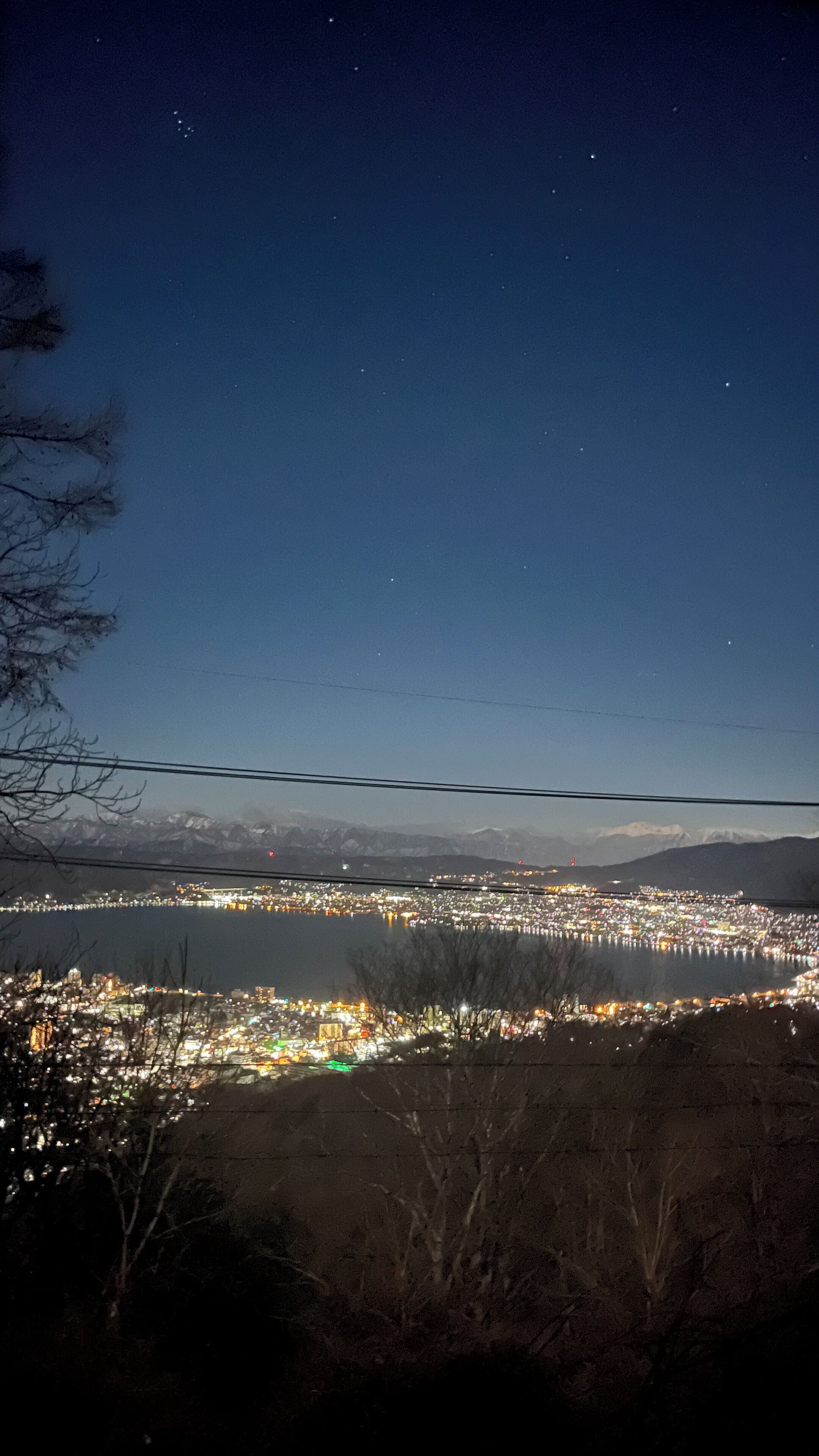 Un paisaje urbano nocturno con vistas a montañas distantes.