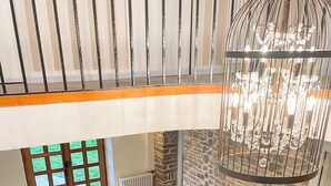 A multi-level interior with a staircase, a stone wall, and a hanging light fixture. - La Maison Gavraise - Stunning house (and Attached Barn) in the Centre of Gavray. (Gavray-sur-Sienne)