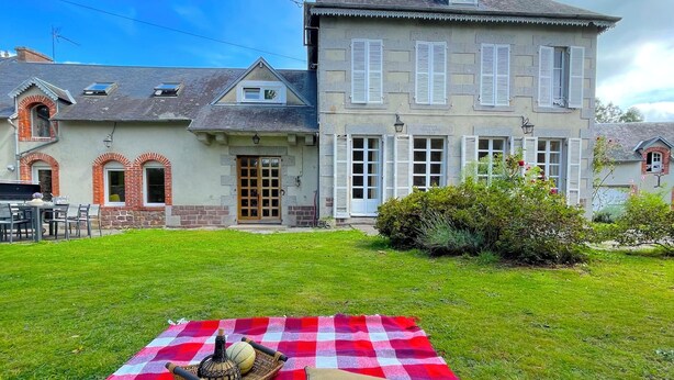 A picnic setup on a checkered blanket in front of a large house with a stone facade and multiple windows. - La Maison Gavraise - Stunning house (and Attached Barn) in the Centre of Gavray. (Gavray-sur-Sienne)