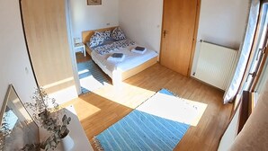 A bedroom with a bed, a wardrobe, a radiator, and a window. - Die Labsalerie am Wörthersee - Apartment with 1 bedroom (Pörtschach am Wörthersee)