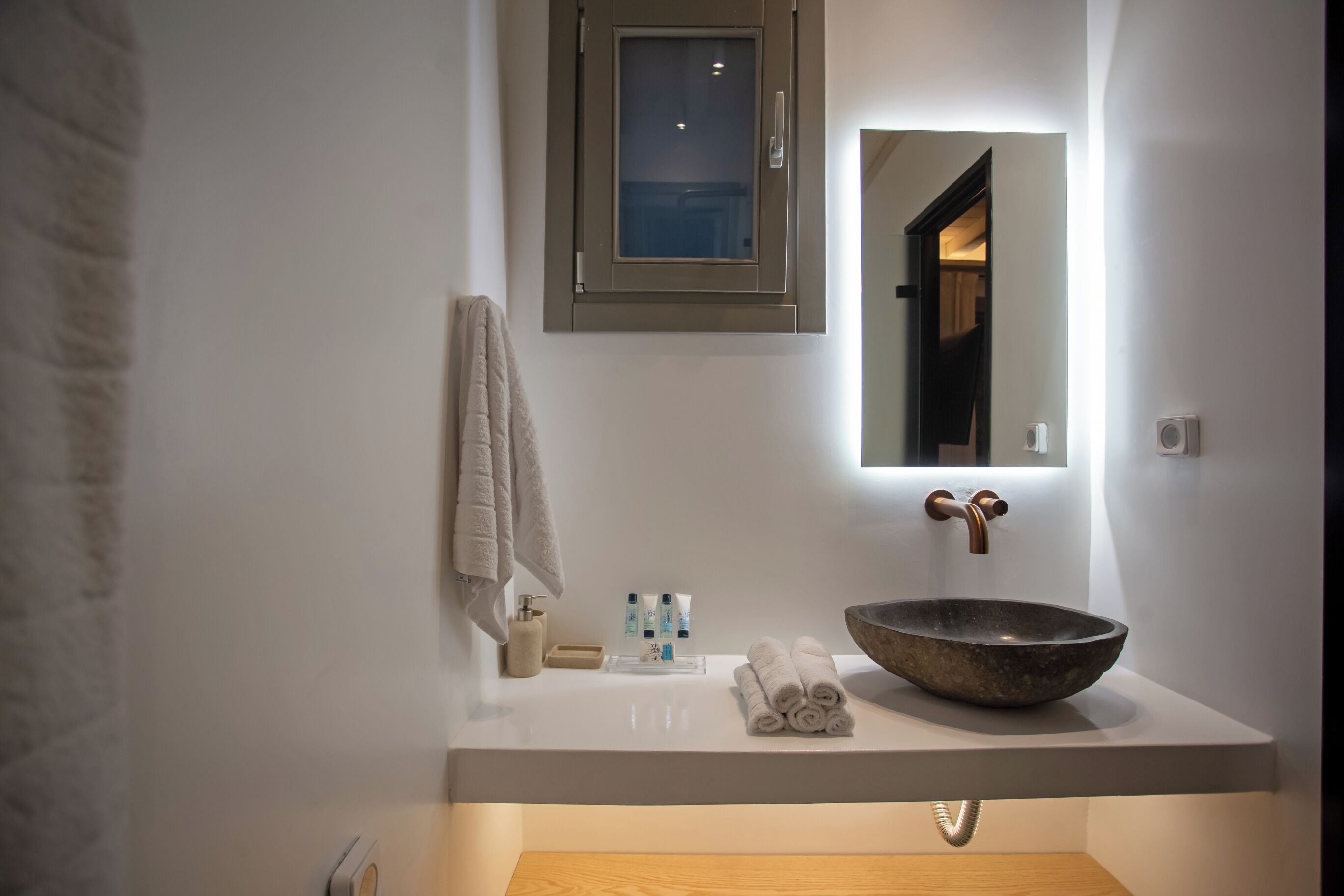 Une salle de bain moderne avec un grand lavabo en forme de cuve, un miroir et un porte-serviettes.