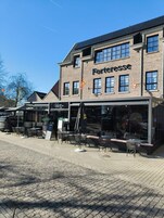 A brick building with a storefront named 'Forteresse' and outdoor seating area.