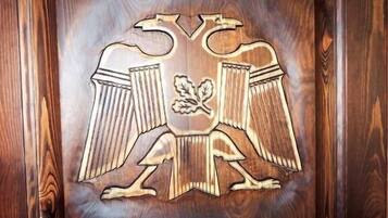 Pared de madera con un emblema tallado que muestra un escudo y una flor.