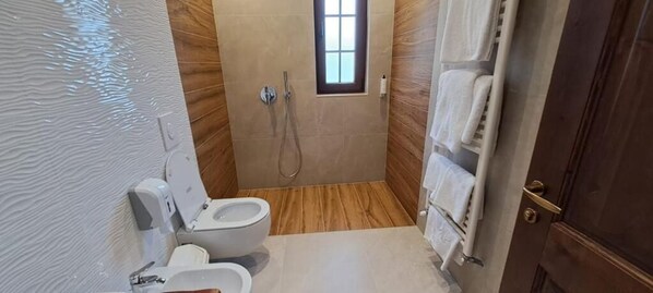 A small bathroom with a toilet, a shower, and a towel rack. - Pupa Winery Serene Stay (Vërtop)