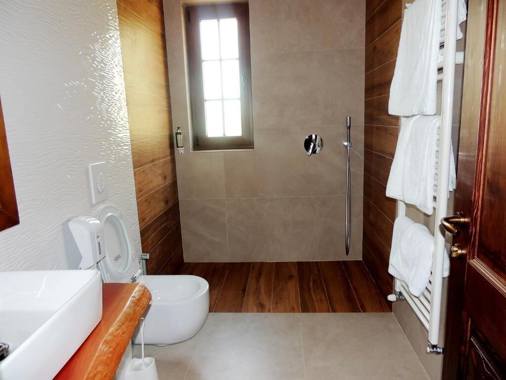 A bathroom with a shower, toilet, and sink.