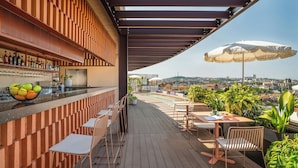 Un bar situé sur le toit d’un immeuble, avec des places assises et une vue sur la ville.
