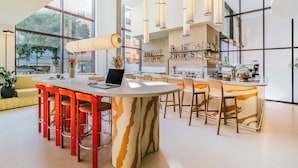 Une cuisine moderne dotée d’un îlot central, d’un coin bar et de grandes fenêtres.