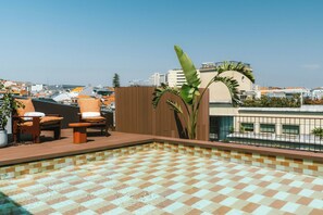 A rooftop pool area with lounge chairs and a tiled floor. - The Social Hub Porto (Porto)