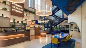 Un intérieur moderne comprenant un comptoir d’accueil, un espace salon et un escalier menant à un niveau supérieur.