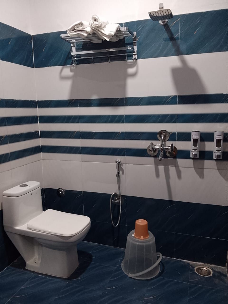 A bathroom with a toilet, a shower, and a sink.