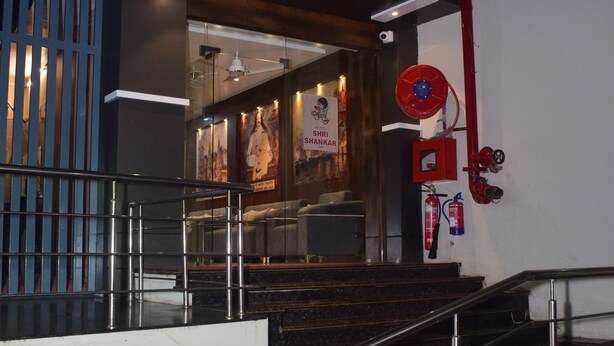 A hotel entrance with a staircase, a fire extinguisher, and a sign for Hotel Shri Shankar Inn. - Hotel shri shankar (Varanasi)