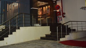 A hotel entrance with a staircase leading to the lobby, a fire extinguisher mounted on the wall, and a sign indicating the hotel name. - Hotel shri shankar (Varanasi)