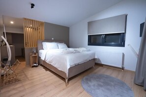 Ein modernes Schlafzimmer mit Bett, Nachttisch und einem Fenster mit Jalousien.