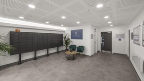 Eine moderne Lobby mit einer Reihe von Schließfächern, einem Empfangstresen und einem Schild mit der Aufschrift 'Ocean House'.