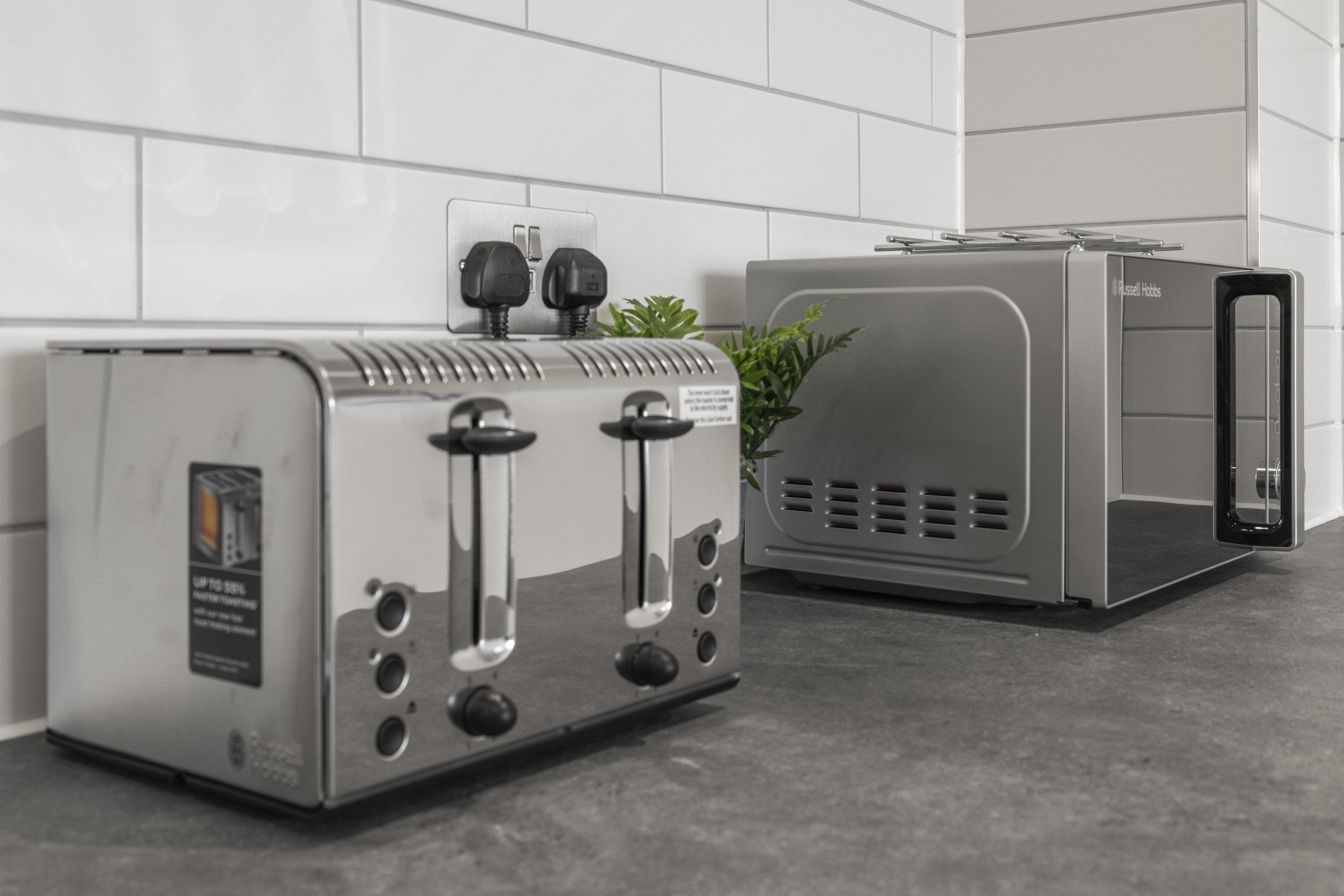 A kitchen with a toaster and a bread box.