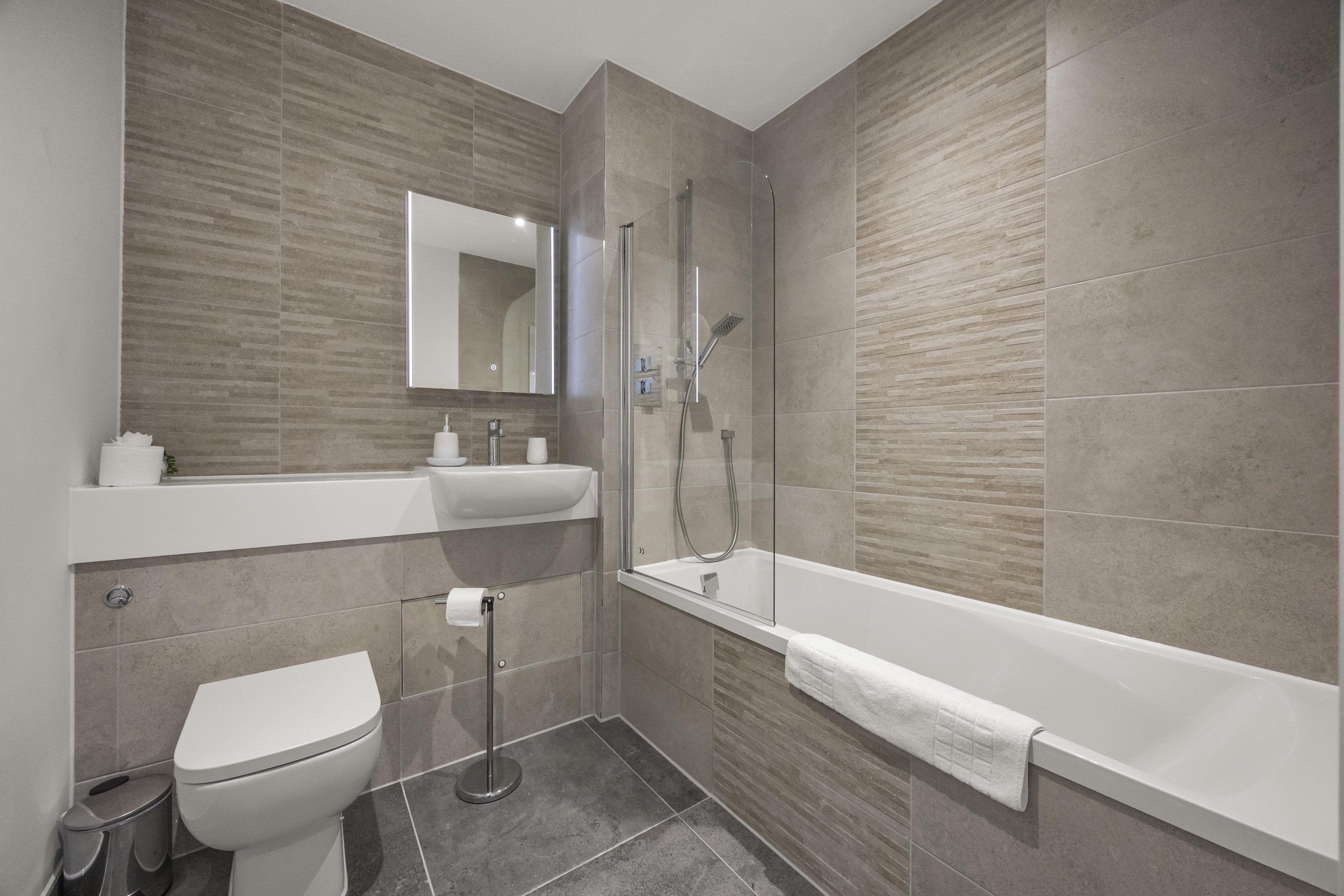 Un baño moderno con inodoro, lavamanos y bañera.