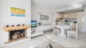 Un salon moderne avec une cheminée, un coin repas et une cuisine.