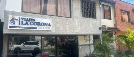 A building with a sign for 'VIAJES LA CORONA' and a parked motorcycle.