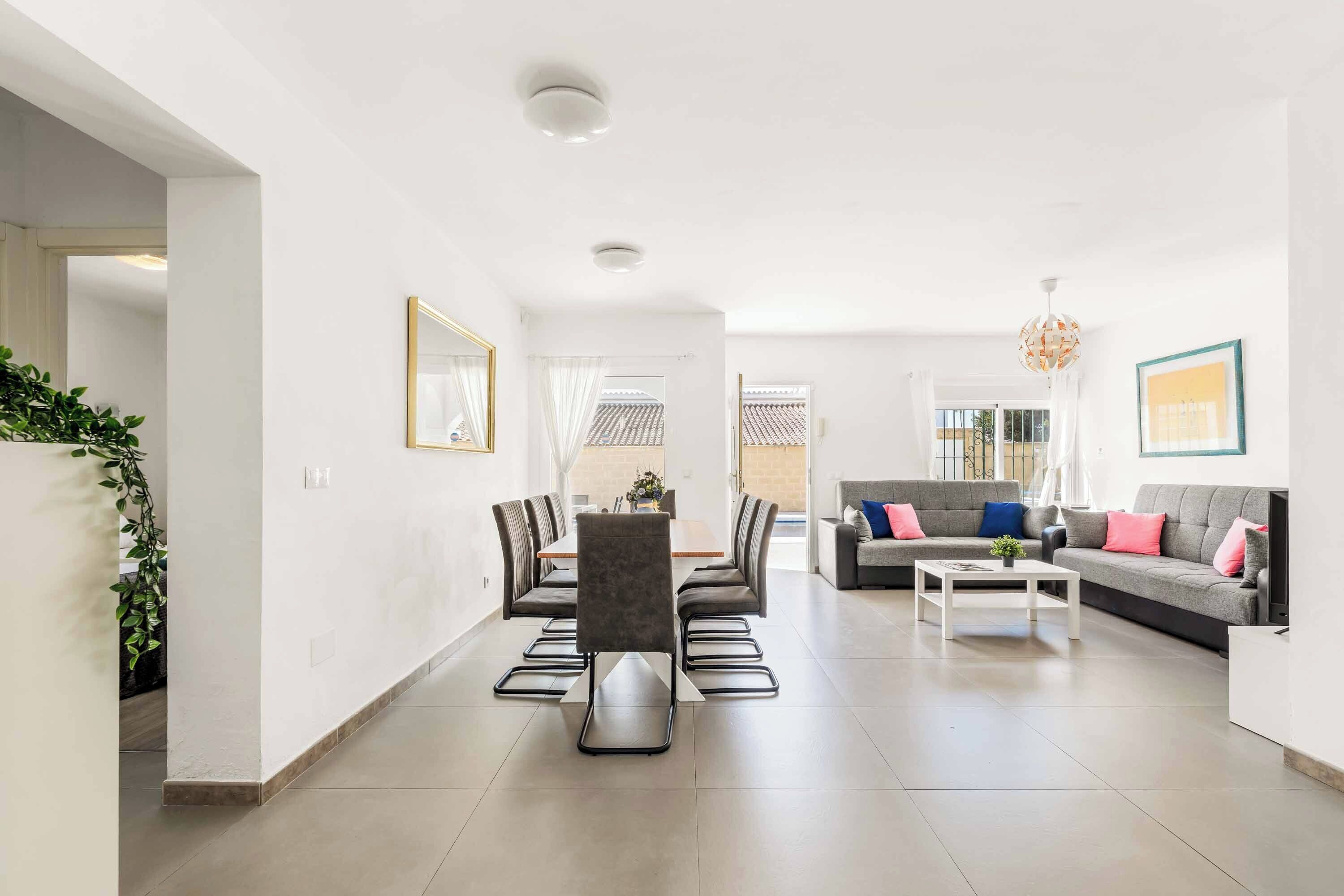 A spacious living area with a dining table, sofas, and a coffee table.